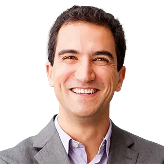 A smiling man in a patterned shirt.